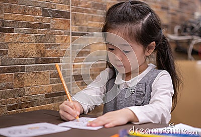 Back to school. Happy smiling pupil drawing at the desk. Cute little preschooler child drawing at home. Kid girl drawing with penc Stock Photo