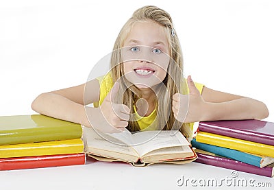 Back to school and happy time! Smiling schoolgirl sitting close to pile of books, showing Ok signs. Stock Photo