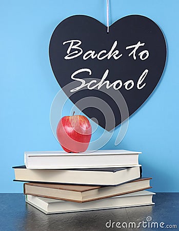 Back to School heart blackboard with red apple and stack of books Stock Photo