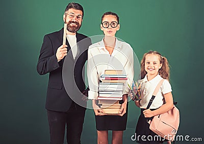 Back to school and home schooling. back to school concept shows teacher and girls with books on green background. Stock Photo