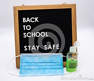 Back to school on pegboard with stay safe message antibacterial gel and childrens face mask Stock Photo