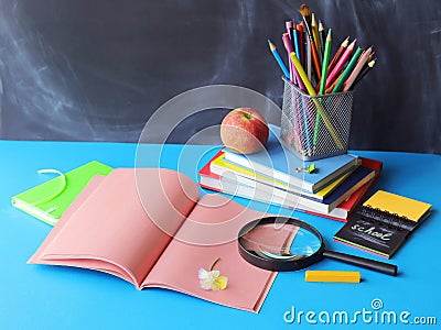 Back to school, stationery, magnifying glass, stack of books, apple on the table, home learning concept Stock Photo