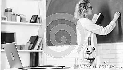 back to school. student girl writing answer at blackboard. beaker and microscope. student doesnt use laptop. biology Stock Photo