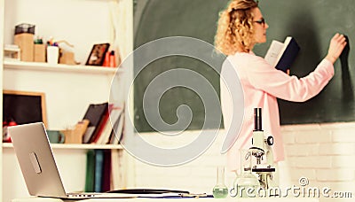 Back to school. student girl writing answer at blackboard. beaker and microscope. student doesnt use laptop. biology Stock Photo