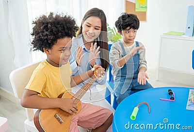 Back to school and summer course. children play guitar in kindergarten Stock Photo