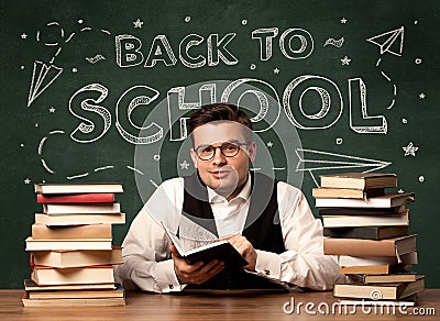 Back to school teacher sitting at classroom desk Stock Photo