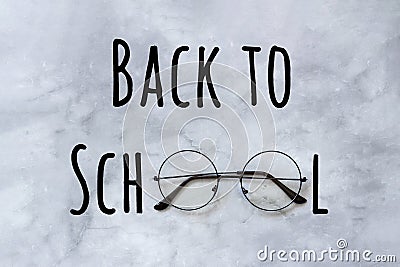 Back to school text and stylish black round eyeglasses spectacles on marble background. Concept education. Top view Greeting card Stock Photo