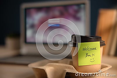 Back to Work Concept. Closeup of Welcome Note on Takeaway Coffee Cup in Office Desk Stock Photo