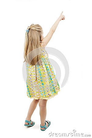 Back view of adorable little girl pointing at wall. Rear view Stock Photo