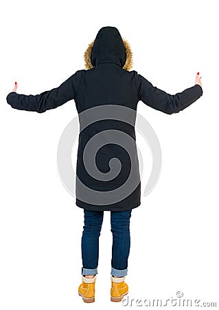 Back view of Beautiful woman in parka looking at wall and Holds Stock Photo