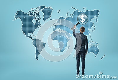 Back view of a businessman looking at world map through magnifying glass and seeing dollar sigh Stock Photo