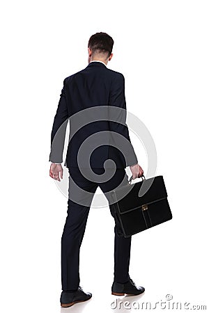 Back view of businessman with suitcase walking Stock Photo