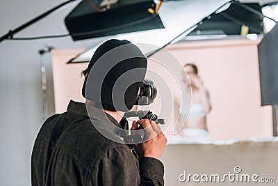 Back view of cameraman working with female model Stock Photo