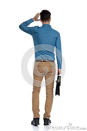 Back view of confused young man scratching head Stock Photo