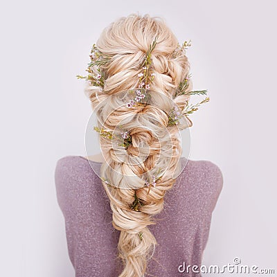 Back view of an elegant trendy hairstyle, interlacing curls and decorating with flower petals Stock Photo