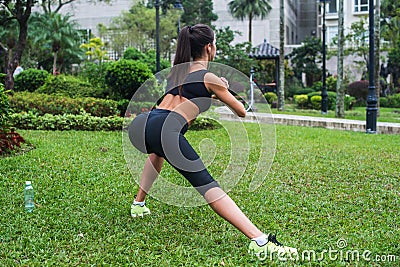 Back view of fit girl doing side lunge exercises outdoors Stock Photo