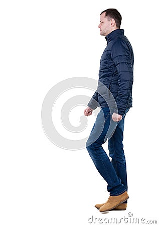 Back view of going handsome man in jeans and jacket. Stock Photo