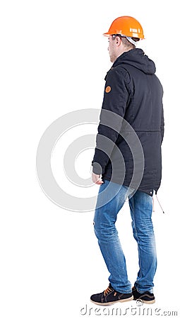 Back view of going worker in a helmet. Walking young engineer. Stock Photo