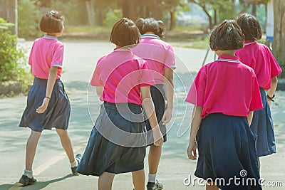 Back view of happiness primary girl students in pink shirt and blue skirt walk to classrooms Editorial Stock Photo