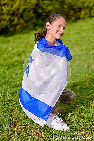 Back view jewish girl with Israeli flag wrapped around her. Stock Photo