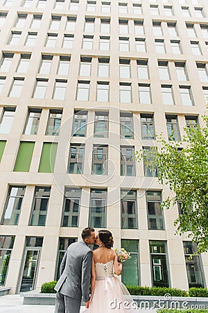 Back view kissing and embracing couple outdoors Stock Photo