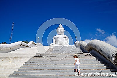 Back view of little girl standing near Big Buddha statue in Phuket, Thailand. Concept of tourism in Asia and famous Stock Photo