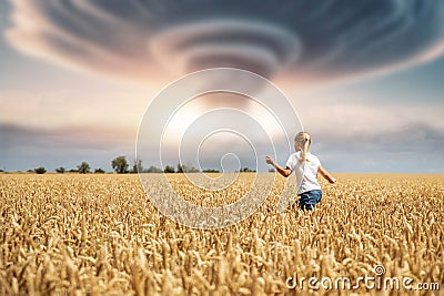 Back view little kid girl walking ripe wheat field imagined nuclear bomb explosion mushroom dramatic cloud background Stock Photo