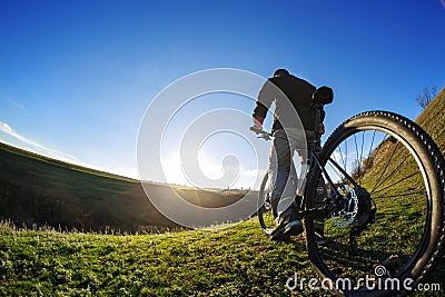 Back view of a man with a bicycle against the blue sky. cyclist rides a bicycle. Stock Photo