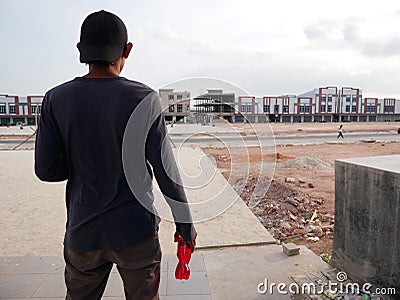 Back view of man with bottle of soda,see the building in front.drinking young guy. Stock Photo