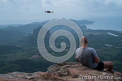 Back view of man drone operator on the mountain view point Stock Photo