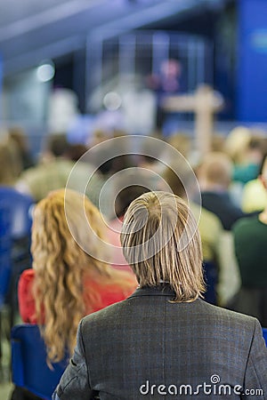 Back View of Man Listening to Professional Lecturer Speaking In front of the People. Editorial Stock Photo