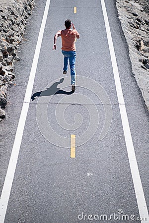 Back view of man running on the road. Athletic young man running outdoor. Stock Photo