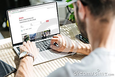 back view of man using laptop with airbnb website Editorial Stock Photo