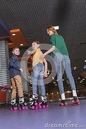 back view of mother and kids skating together Stock Photo