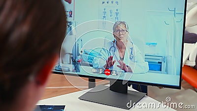 Back view of nurse discussing on webcam with senior stomatologist Stock Photo