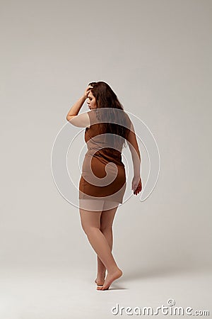 Plus size fashion model in brown short dress Stock Photo