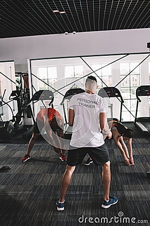 back view of personal trainer supervising Stock Photo