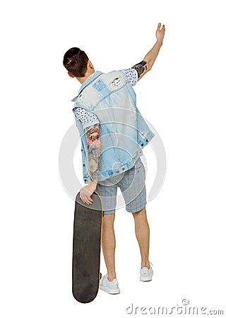 Back view of a pointing man with a skateboard Stock Photo