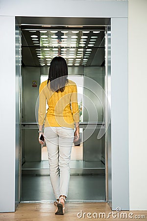 Back view portrait of a woman going in elevator Stock Photo