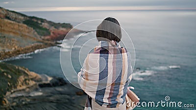 Back view relaxed woman standing in front gray ocean. Girl looking on seascape. Stock Photo