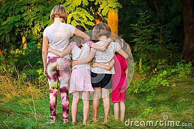 Back view of sad children stand in hug together in summer Stock Photo