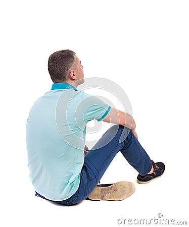Back view of seated handsome man in polo looking up. Stock Photo