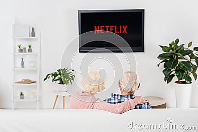 back view of senior couple watching netflix on tv Editorial Stock Photo