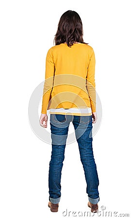 Back view of standing young beautiful brunette woman in yellow Stock Photo