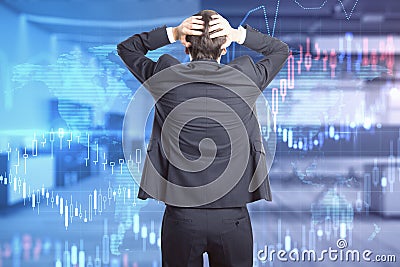 Back view of stressed young businessman in suit standing in modern office interior with forex chart. Crisis and trade concept. Stock Photo