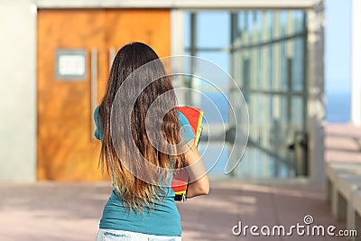 Back view of a teen girl walking towards the school Stock Photo