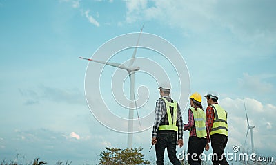Back view of three engineers discussing and progress check wind turbine field Stock Photo