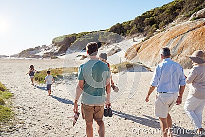 Back view of three generation white family exploring together on a sunny beach Stock Photo