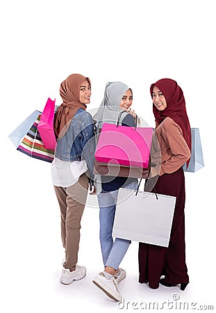 Back view of three hijab women carrying paper bag after shopping together Stock Photo
