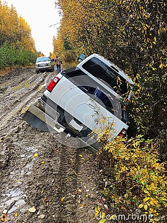 Back view of a truck that has driven off the edge of a muddy road Stock Photo